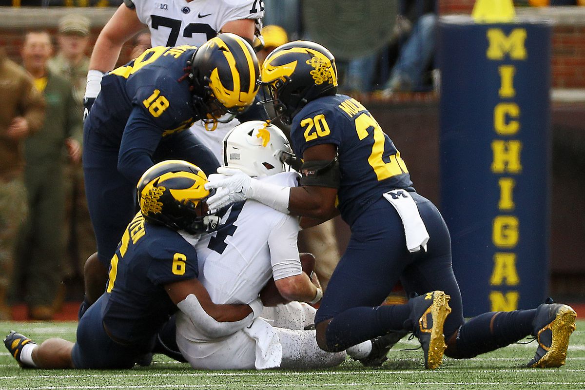 Three Michigan players corral the Penn State runner