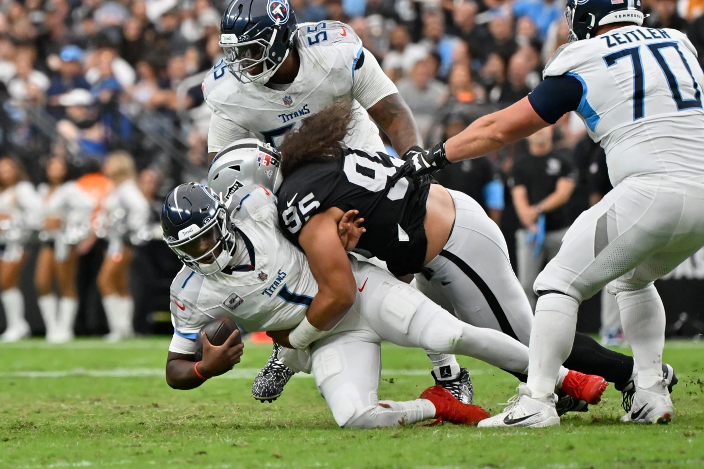 Cam Ward getting sacked by the Raiders defensive line