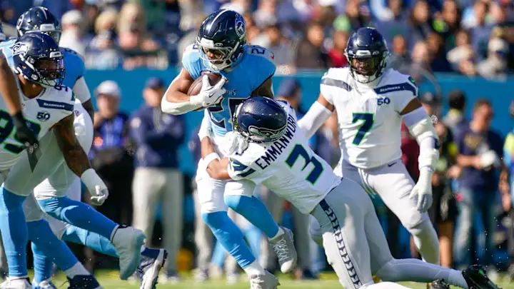 Titans runner gets tackled bye Seahawks defender