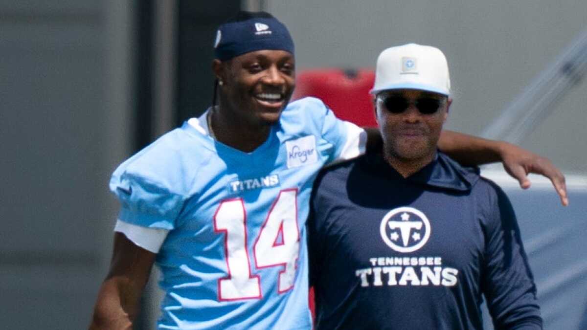 WR Carnell Tate has his arm around a coach Tony Oden for the Titans